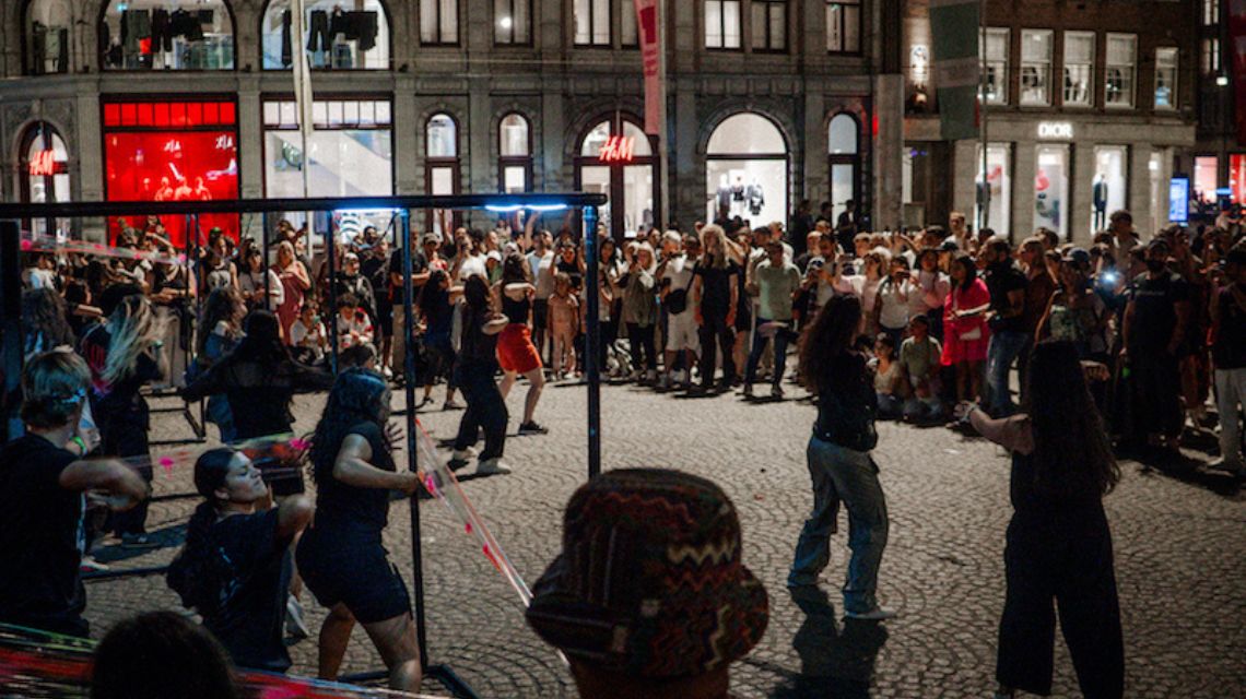 Onlookers fill the city square to watch the students’ performance.